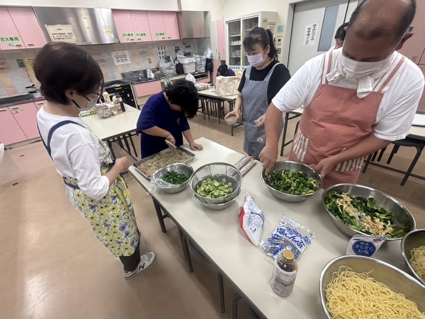 調理室で下ごしらえをするボランティアと子ども